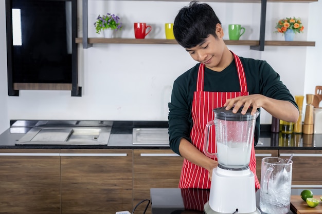 Retrato de un joven feliz en la cocina