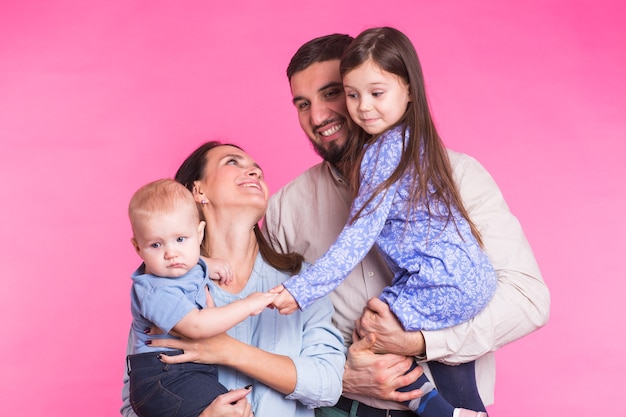 Foto retrato de joven feliz familia de raza mixta sobre pared rosa