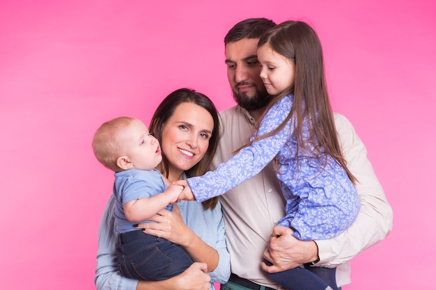 Foto retrato de joven feliz familia de raza mixta sobre pared rosa