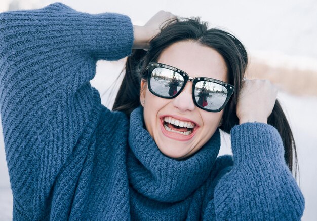 Foto retrato de una joven feliz con gafas de sol