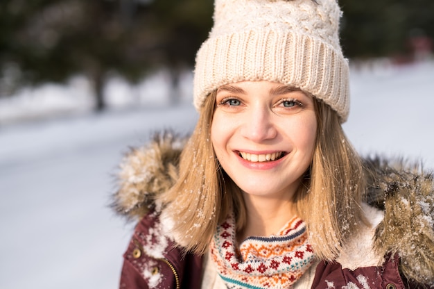 Retrato de la joven feliz. Niña sonriente con ropa de invierno cubierto de nieve