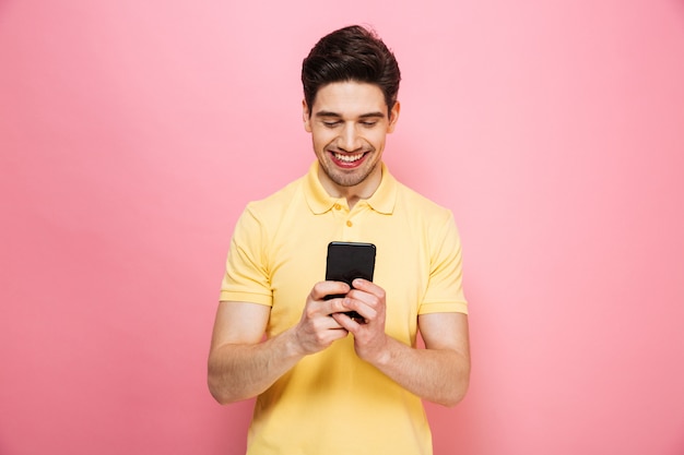 Retrato de un joven feliz mediante teléfono móvil