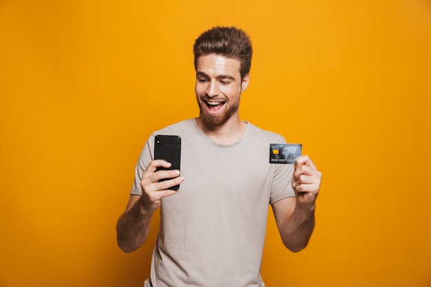 Retrato de un joven feliz mediante teléfono móvil