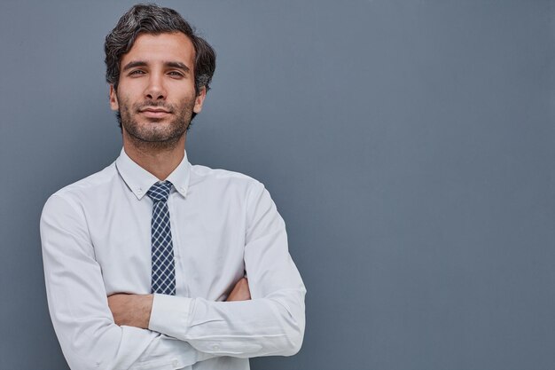 Retrato de un joven en un fondo gris con una camisa que irradia éxito