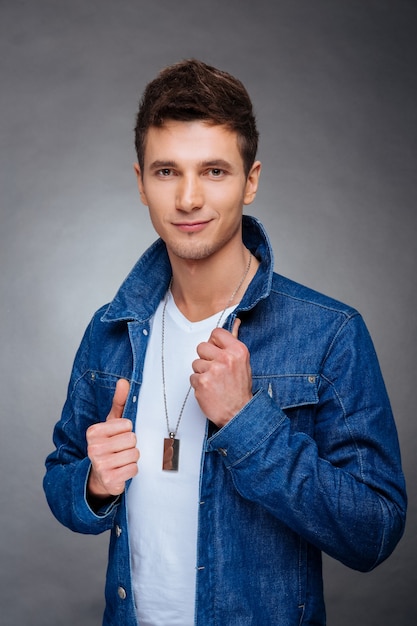 Foto retrato, de, un, joven, en, un, fondo gris, chaqueta vaquera