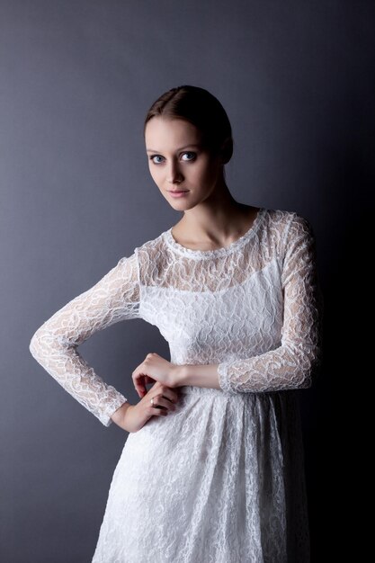 Retrato de una joven frágil en un vestido de encaje blanco