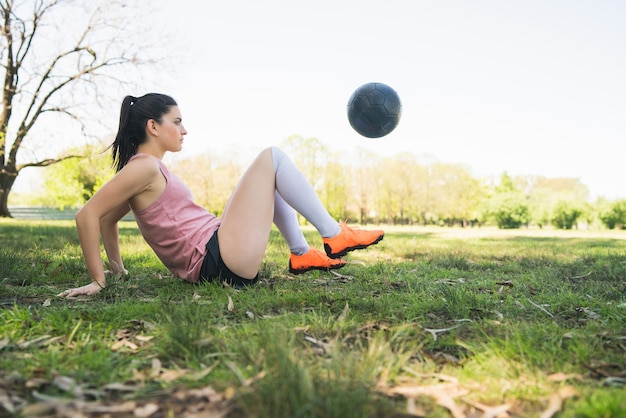 Retrato de joven futbolista entrenando y practicando habilidades en el campo de fútbol.