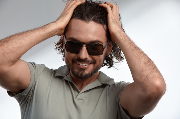 Foto retrato de un joven con gafas de sol contra un fondo blanco