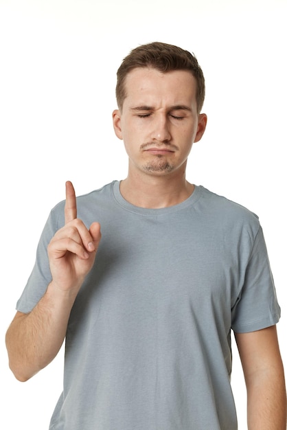 Retrato de un joven gracioso haciendo muecas sobre un fondo blanco