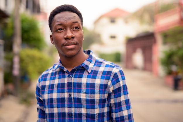 Retrato de joven guapo africano en las calles al aire libre