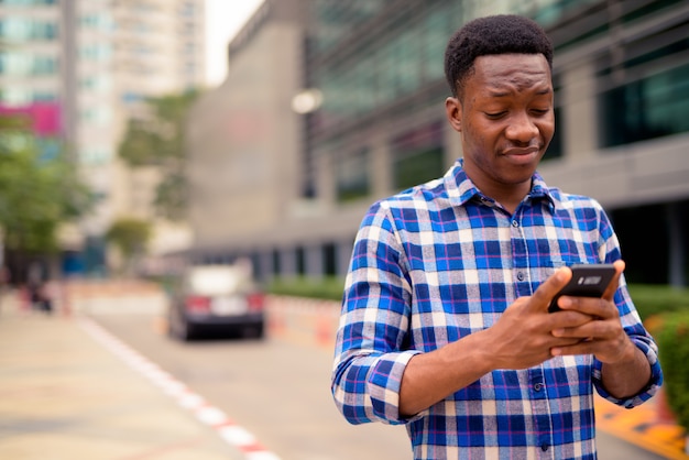 Retrato de joven guapo africano en las calles de la ciudad al aire libre