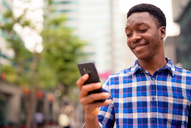 Retrato de joven guapo africano en las calles de la ciudad al aire libre