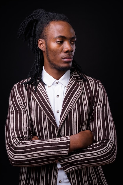 retrato, de, joven, guapo, africano, hombre de negocios, con, rastas, en, negro