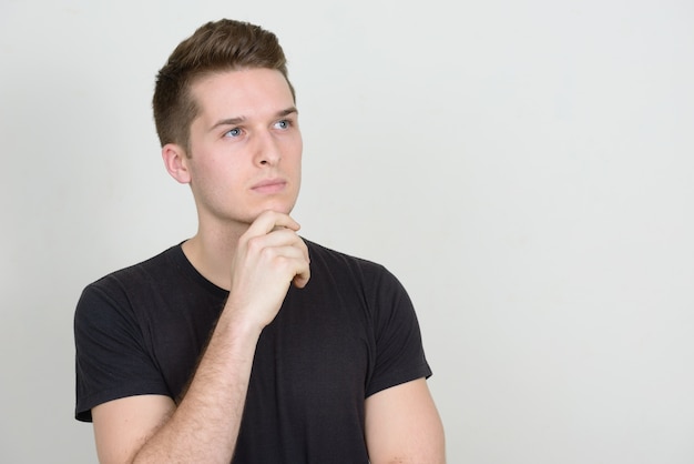 Foto retrato de joven guapo contra la pared blanca