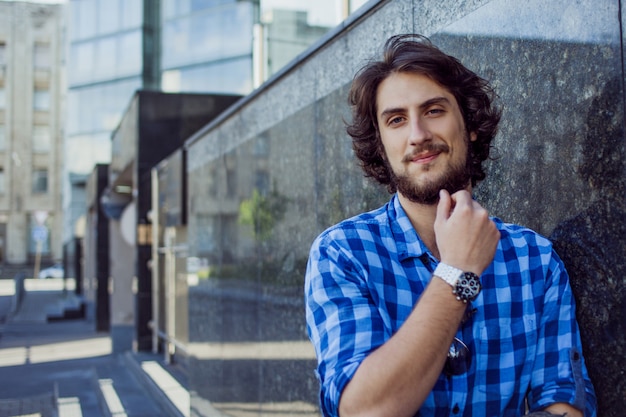 Retrato de joven guapo elegante en la calle.