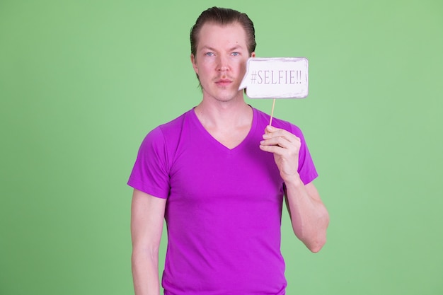 Retrato de joven guapo escandinavo con camisa púrpura contra chroma key