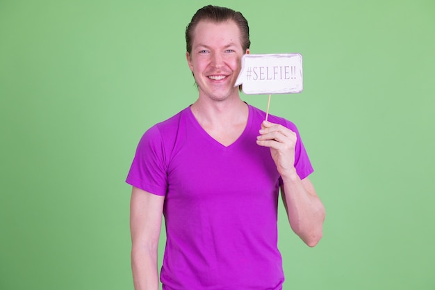 Retrato de joven guapo escandinavo con camisa púrpura contra chroma key