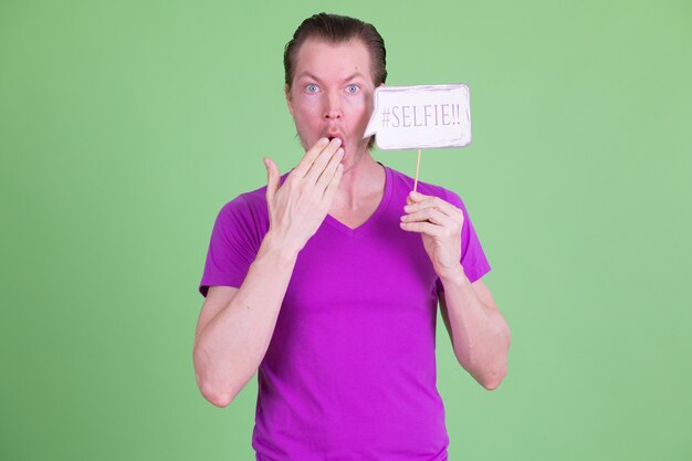 Retrato de joven guapo escandinavo con camisa púrpura contra chroma key