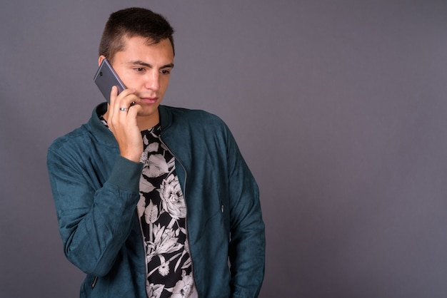 Retrato de joven guapo hablando por teléfono móvil