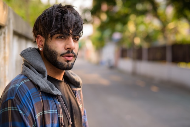 Retrato de joven guapo hipster indio barbudo en las calles al aire libre