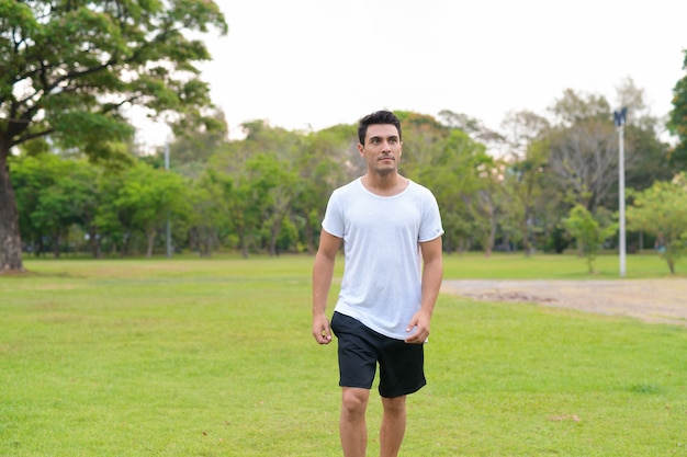 Retrato de joven guapo hispano en el parque al aire libre