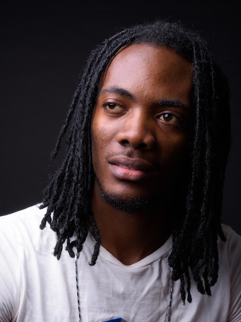 retrato, de, joven, guapo, hombre africano, con, rastas, en, negro