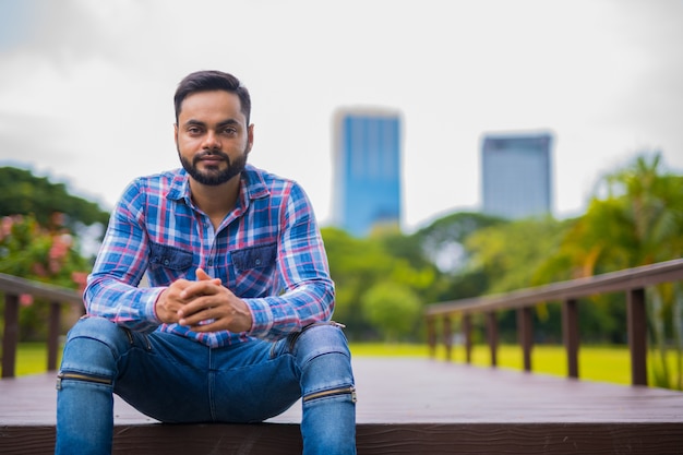 Retrato de joven guapo indio barbudo en el parque Lumpini