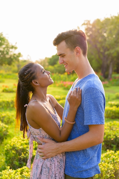 Retrato de joven guapo y joven bella mujer asiática relajándose juntos en el parque