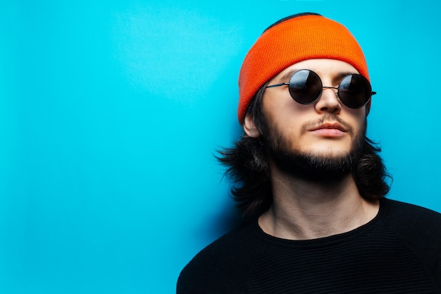 Retrato de joven guapo con largo cabello castaño y actitud confiada