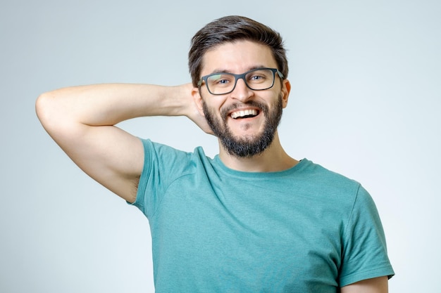 Retrato de un joven guapo y positivo aislado sobre un fondo gris