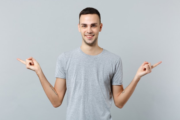 Retrato de joven guapo en ropa casual, apuntando con el dedo índice a un lado