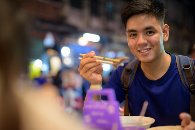 Retrato de joven guapo turista asiático explorando en Chinatown en Bangkok, Tailandia