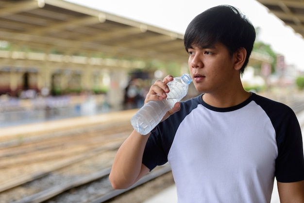 Retrato de joven guapo turista filipino en la estación de tren Hua Lamphong en Bangkok