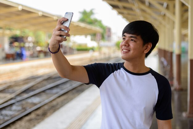 Retrato de joven guapo turista filipino en la estación de tren Hua Lamphong en Bangkok