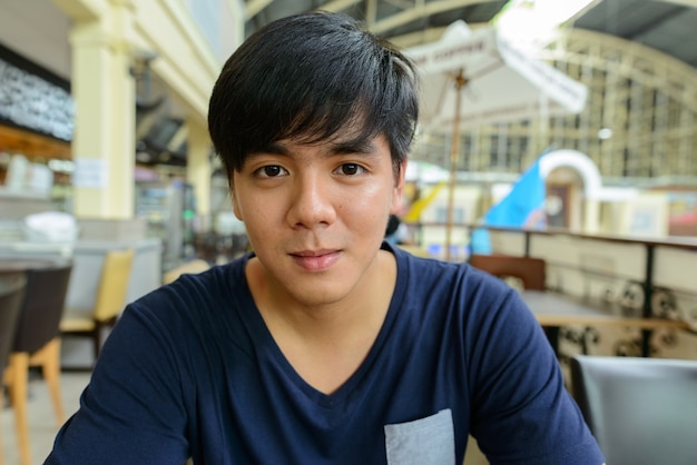 Retrato de joven guapo turista filipino en la estación de tren Hua Lamphong en Bangkok