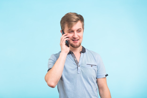 Retrato de joven hablando por teléfono sobre azul