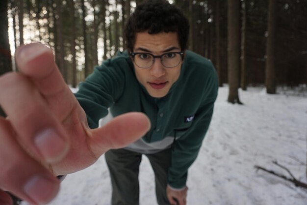 Foto retrato de un joven haciendo ejercicio en la nieve