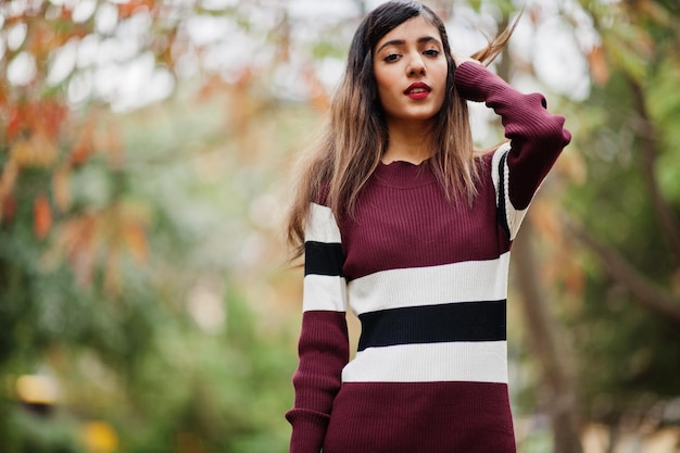 Retrato de una joven y hermosa adolescente india o del sur de Asia vestida en un parque de otoño en Europa