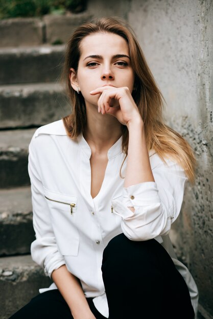 Retrato de joven hermosa al aire libre en camisa blanca