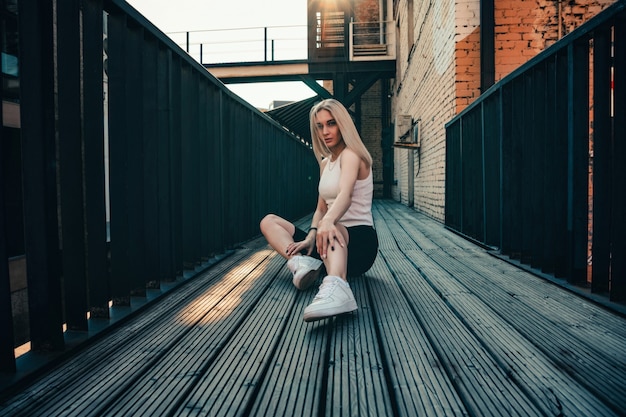 Retrato de una joven hermosa en una calle de la ciudad en verano