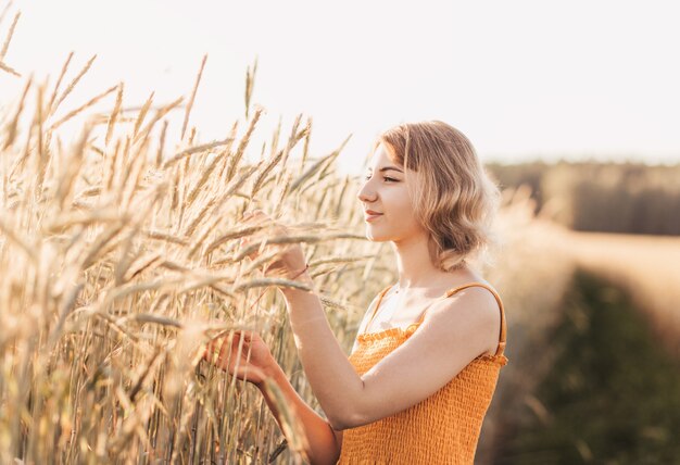 Retrato de una joven hermosa en un campo de trigo