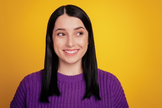 Retrato de joven hermosa linda chica alegre sonriendo mirando a cámara sobre fondo amarillo.