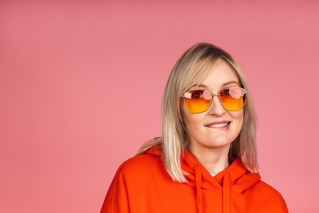 Retrato de una joven hermosa linda rubia alegre sonriendo aislada sobre fondo rosa.