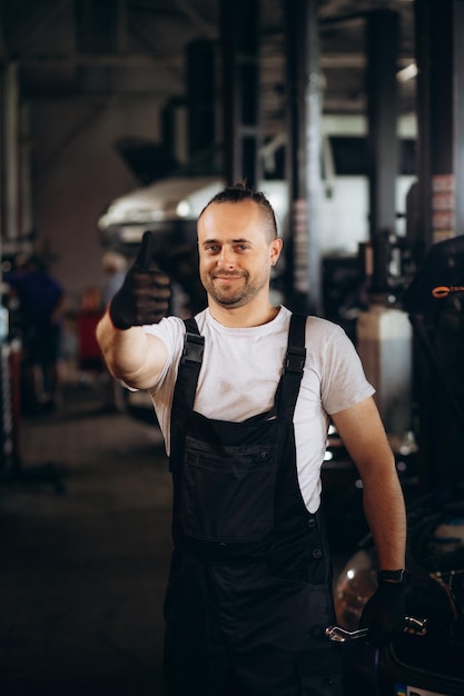 Retrato de una joven y hermosa mecánica de automóviles en un taller de automóviles al fondo del servicio