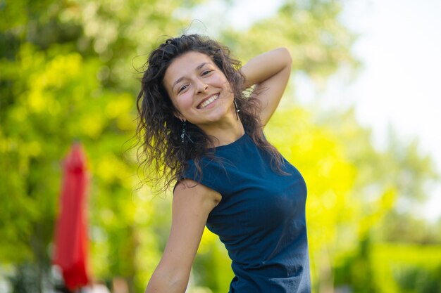 Retrato de joven hermosa morena disfruta de un brillante día de verano en el parque verde