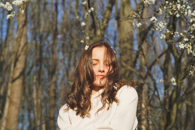 Retrato de joven hermosa mujer entre árboles en flor moda y belleza concepto de primavera