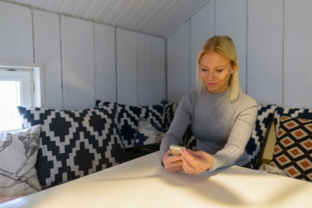 Retrato de joven hermosa mujer escandinava rubia relajante en casa