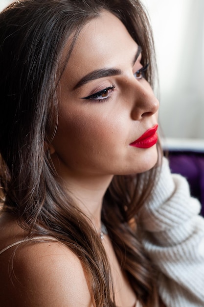 Retrato de joven hermosa mujer europea positiva en casa