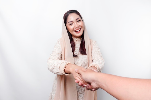 Retrato de una joven y hermosa mujer musulmana asiática con un pañuelo en la cabeza haciendo un gesto de saludo de Eid Mubarak