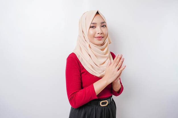 Retrato de una joven y hermosa mujer musulmana que usa un hiyab haciendo un gesto de saludo de Eid Mubarak